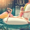 deux filles sur un licorne gonflable dans la piscine