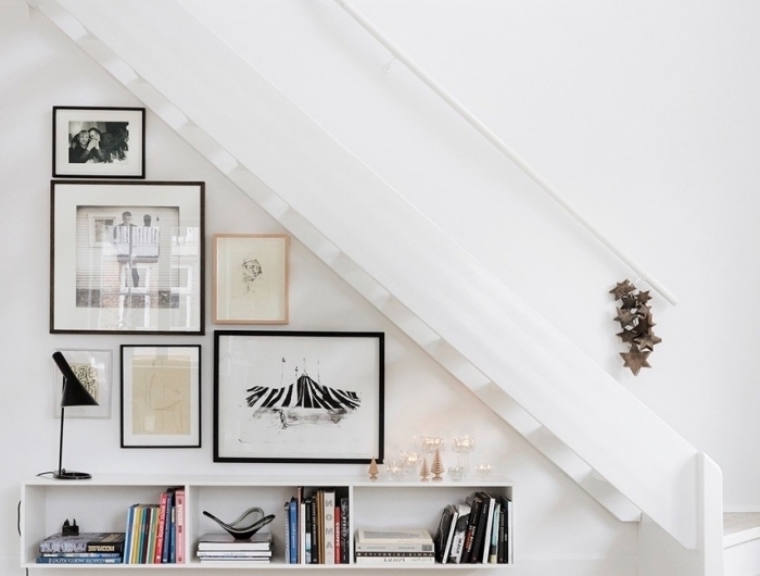 décoration minimaliste mur de cadres meuble rangement sous escalier tapis blanc et noir