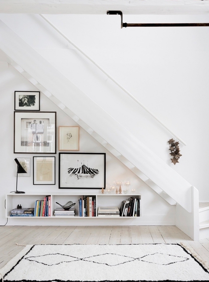 décoration minimaliste mur de cadres meuble rangement sous escalier tapis blanc et noir