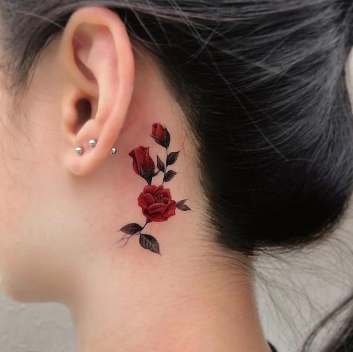 femme cehveux noirs avec tatouage fleur minimaliste derrièer l oreille