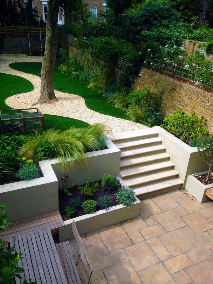 idee jardin paysagiste zen galets blancs plantes vertes terrasse banquette et table en bois foncé