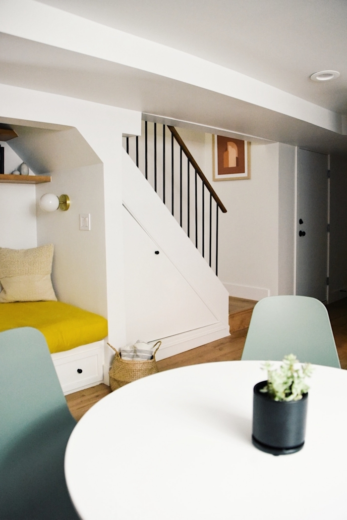 meuble sous escalier banquette assise rangement tiroirs housse jaune coussins décoratifs en beige