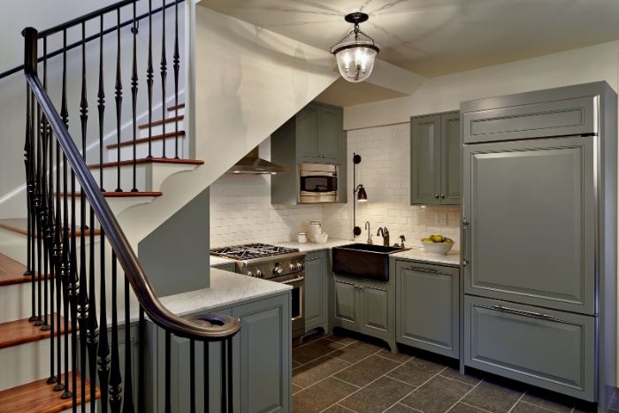 modele de cuisine grise sous escalier avec credence mur carrelage blanc évier noir plan de travail blanc escalier quart tournant