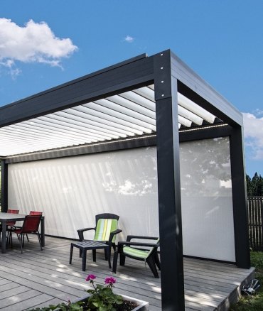 pergola bioclimatique en aluminium au dessus des deux chqises et une table a cafe en pvc