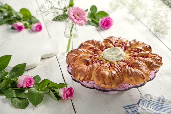 repas fete des meres sur une table en bois avec des roses et un pain soleil