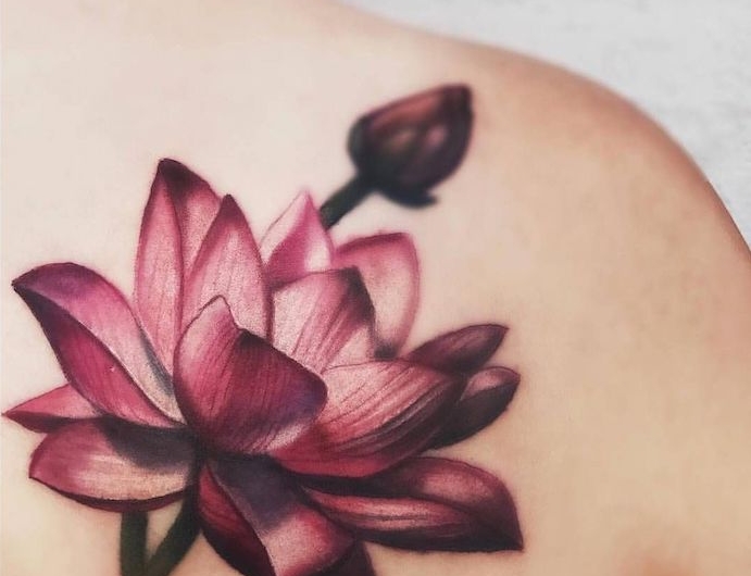 tatouage fin femme au dessin lotus violet sur le dos