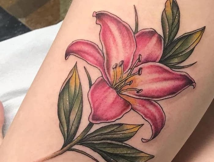 tatouage floral de fleur de lis rose sur)le bras d une femme