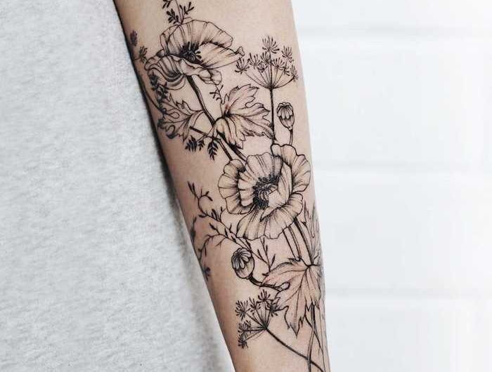 tatouage ornemental avec des fleurs en noir et blanc sur l avant bras