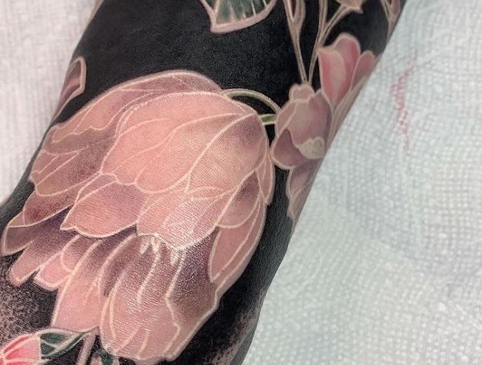 tatouage style renaissance avec des fleurs en couleur nu sur un fond noir