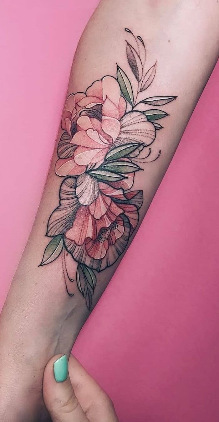 un bras feminine avec des ongles en menthe et un tatouage floral fin