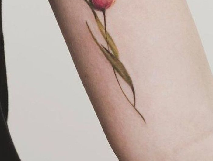 un petit tatouage de tulip en orange sur l avant bras