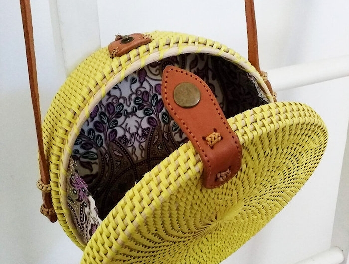 un sac ronde en rotin jaune accroché a une echelle