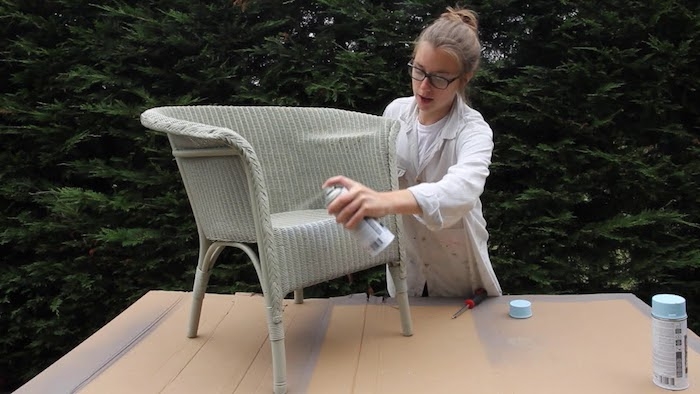 une femme aux lunettes qui montre comment teindre du rotin a l aide de painture en aérosole