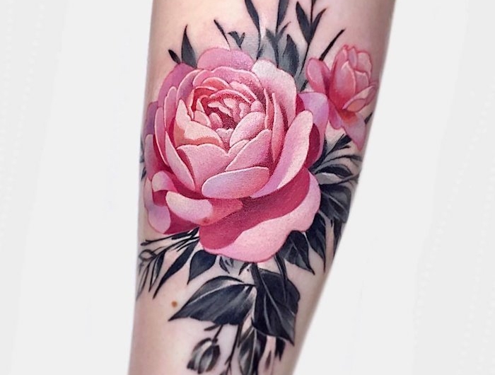 une femme avec tatouage rose avant bras des feuilles noirs