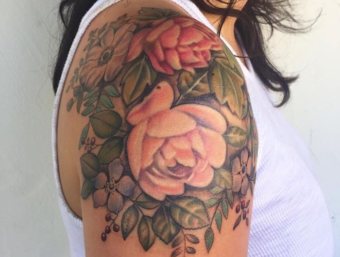 une femme en top blanc avec un tatouage fleur epaule des roses et pivoines