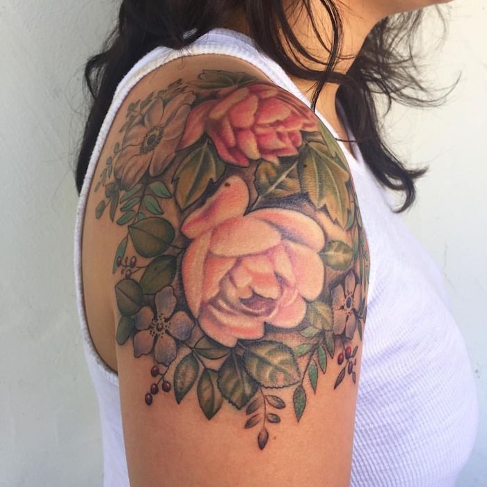 une femme en top blanc avec un tatouage fleur epaule des roses et pivoines