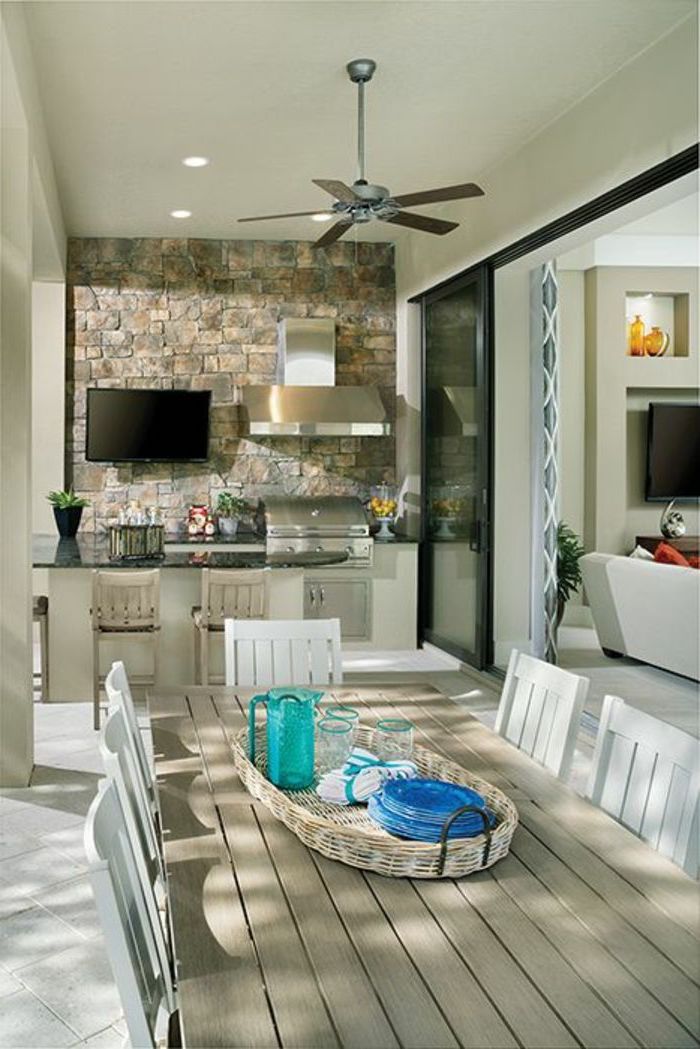 une idée de cuisine dans veranda aménagé avec une grille et aspirateur une salle a manger avec des chaises au milieu de l espace