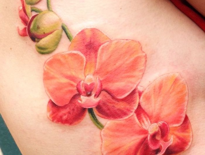 une idée de tatouage orchidée en orange sur la cuisse