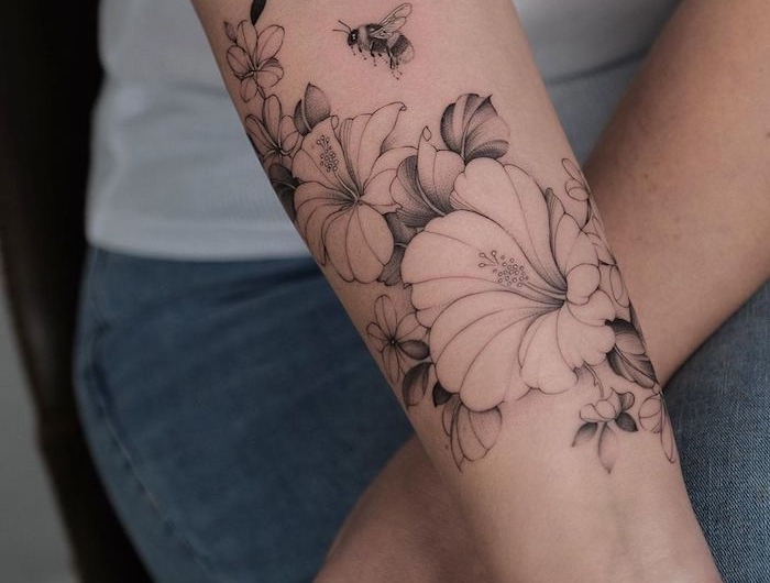 une idée de tatouage simple et delicat sur l avant bras des hibiscus sans couleurs
