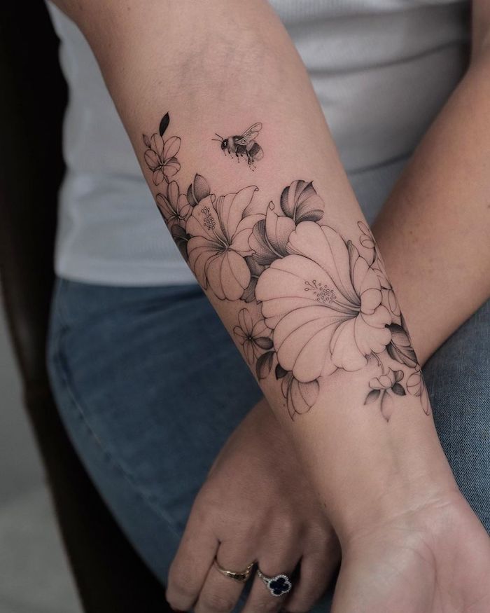 une idée de tatouage simple et delicat sur l avant bras des hibiscus sans couleurs