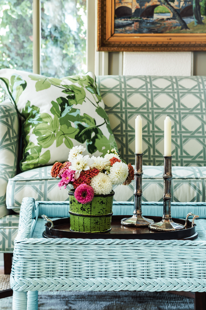 une table base turquoise peinture pour meuble en rotin devant un canapé avec vase a fleurs au dessus jpg