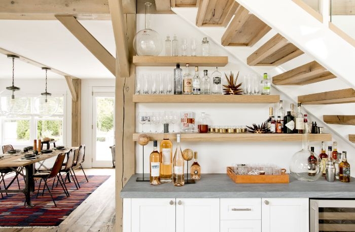 étagères ouvertes de bois sous escalier bois meuble cuisine blanc et plan de travail gris ouverture sur salle à manger