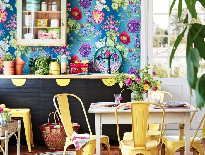 deco hippie chic papier peint bleu motifs floraux armoires noir mat chaises jaunes plantes