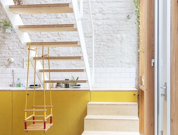 exemple escalier amovible dans cuisine façade jaune mur de briques blanches carrelage blanc plantes suspendues
