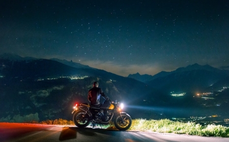 motocyclete noir orange belle vue vers la montagne pendant la nuit