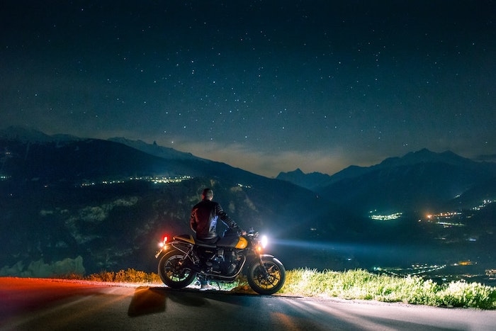 motocyclete noir orange belle vue vers la montagne pendant la nuit