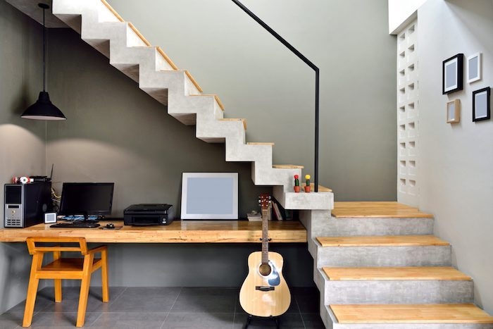 amenagement dessous escalier bureau et chaise en bois guitare mur gris foncé escalier en béton et bois