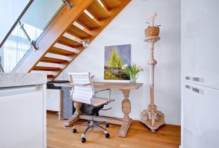 aménagement sous escalier ouvert en bois et blanc peinture et plante sur le bureau