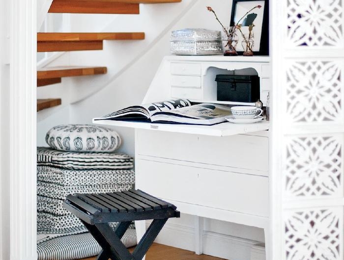 aménagement sous escalier sans contremarche en bois déco en blanc tapis et coussins en noir et blanc cadre de photo noir