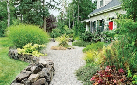 bordure de jardiin en pierre allée en gravier jardin avec buissons et des fleurs devant une belle maison