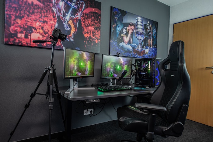 chambre gaming équipée avec chaise bureau gris écrans tapis gris anthracite équipements gamer