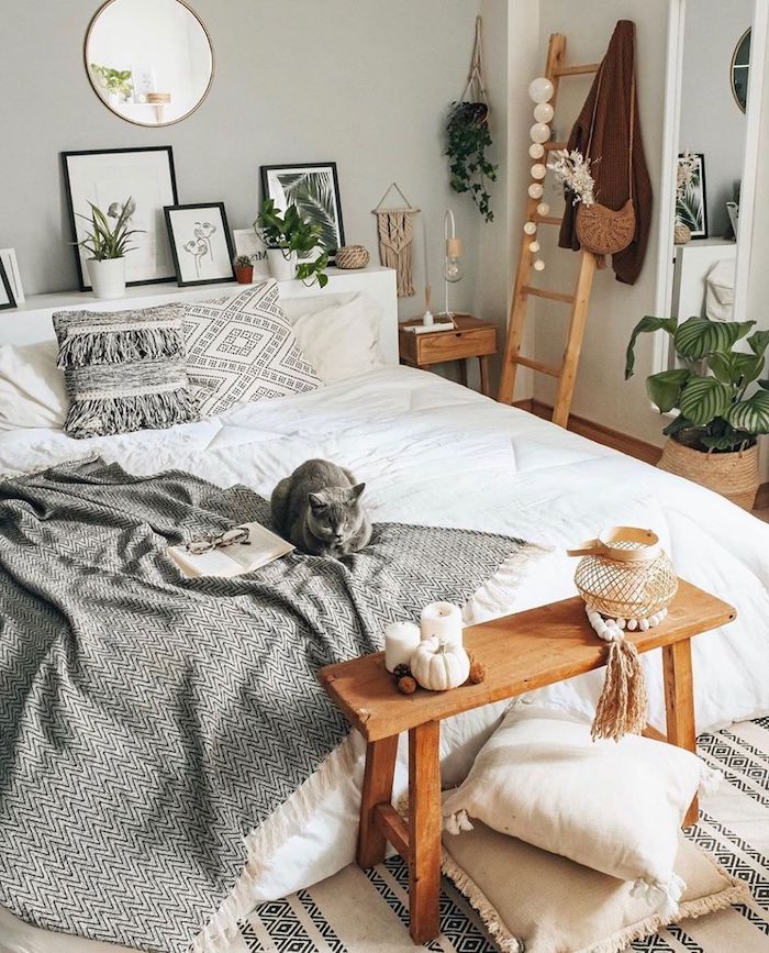 chambre style bohème linge de lit blanc couverture grise cadres de photos meubles en bois clair coussins en blanc et gris