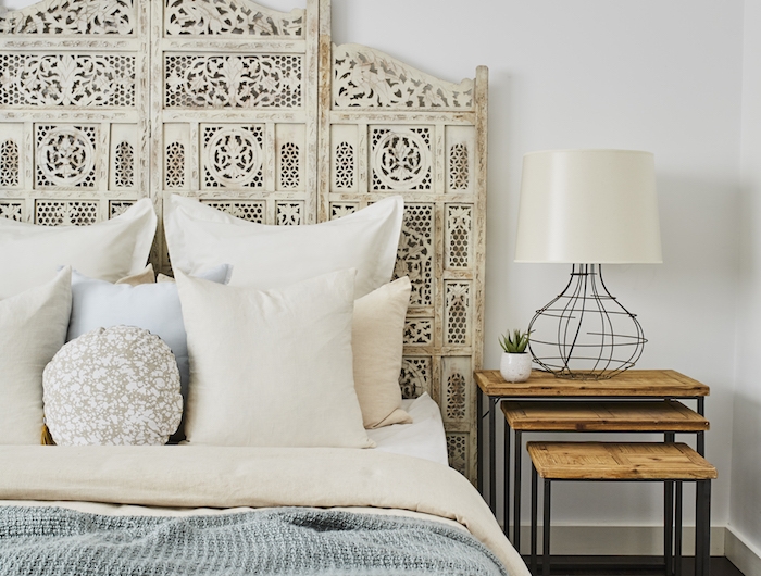 chambre style bohème tete de lit blanche coussins blancs couvertures en beige et bleu table de nuit en bois et métal mur blanc