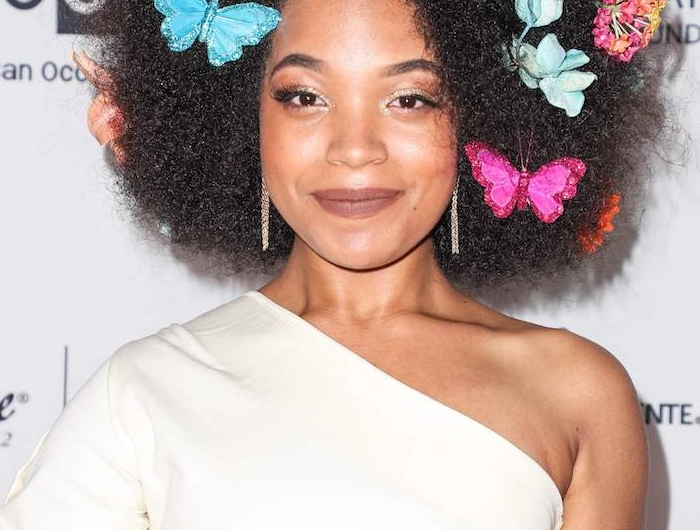 coiffure afro femme avec de gros volume et des décorations papillons