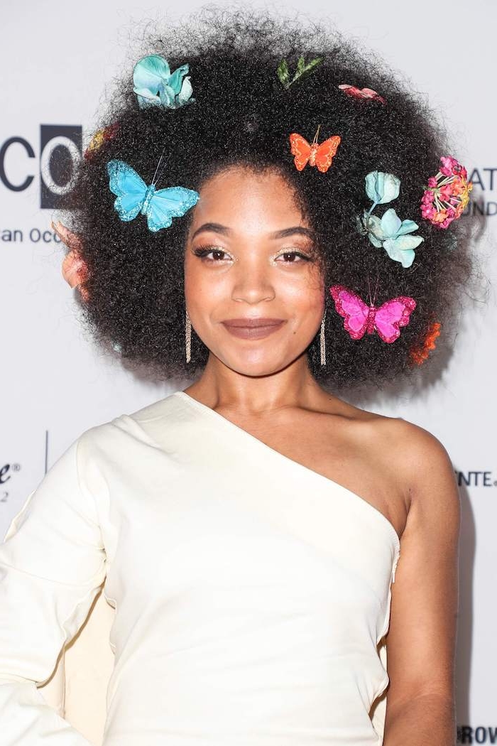 coiffure afro femme avec de gros volume et des décorations papillons