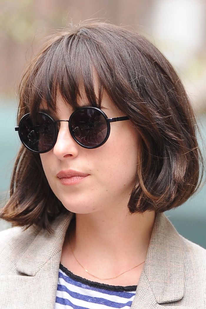 coiffure cheveux court avec frange effilée dakota johnson aux luntettes de soleil rondes et noires