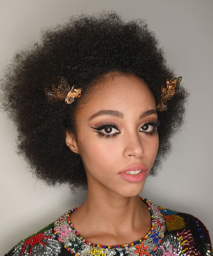 coupe afro femme avec volume cheveux noirs frisés maquillage des yeux contour noir