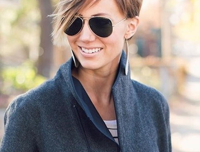 coupe dégradée courte avec frange dégradée femme aux lunettes de soleil noires au manteau gris foncé