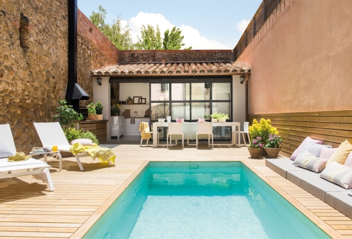 cuisine d été extérieure couverte façade vitrage hotte noir mat meuble bain soleil terrasse bois piscine