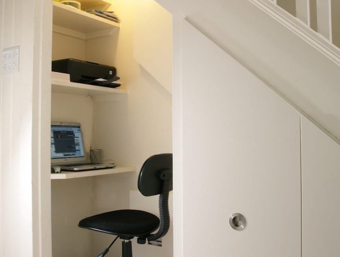 escalier avec rangement cloison peinte en blanc chaise de bureau noir bureau simple et étagères blancs