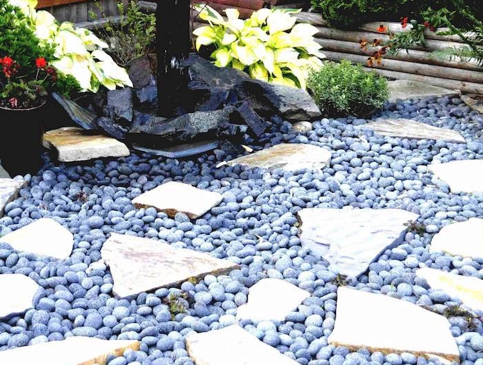 idee deco jardin avec cailloux bleus et pierres fontaine et fleurs dans le jardin