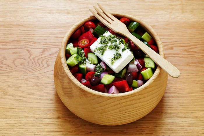 idée salade composée bol en bois plein de légumes fourchette en bois table de bois