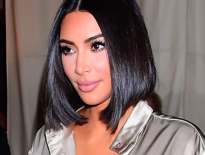 kim kardashian au carré asymétrique noir lisse avec raie au milieu en chemisier argenté