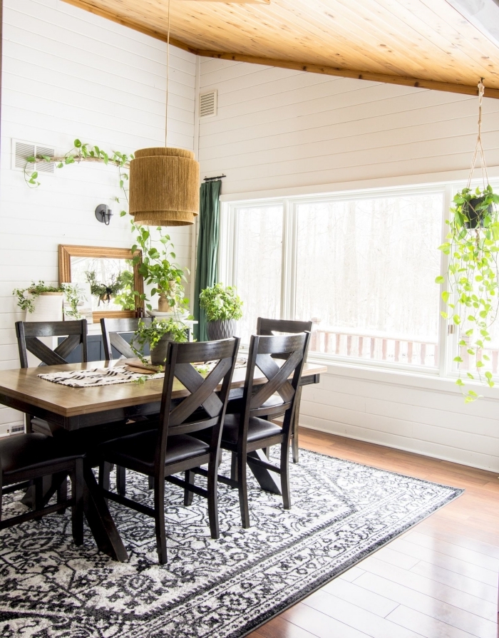 plante suspendue décoration salle a manger tapis blanc et noir motifs plafond bois rideaux verts
