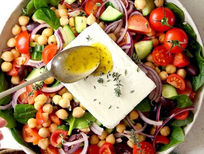salade grecque saladier plein de concombres tomates olives épinards oignons feta et pois chiche