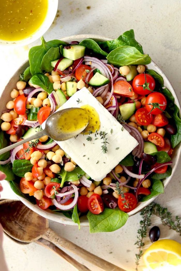 salade grecque saladier plein de concombres tomates olives épinards oignons feta et pois chiche